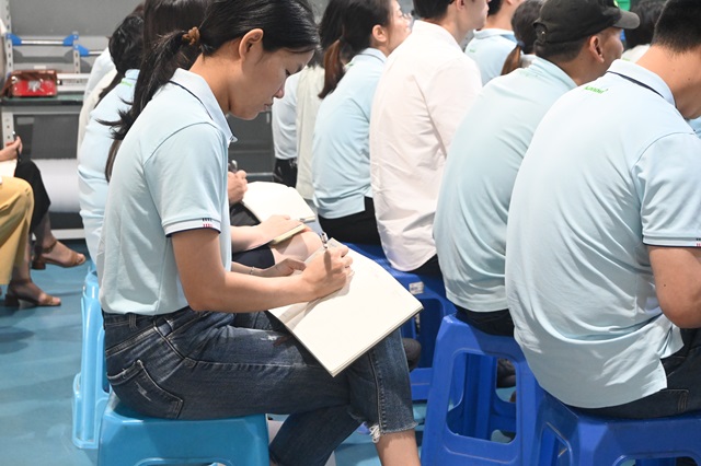同事认真记录笔记中