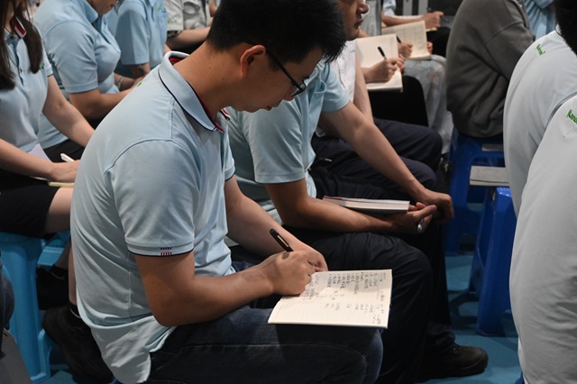 同事认真记录笔记中